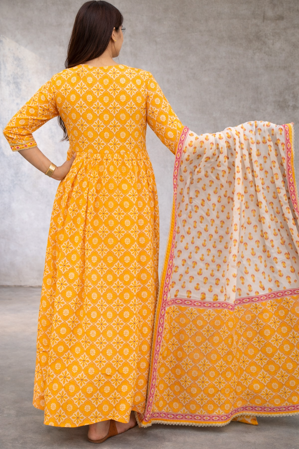 Women's yellow floral printed Anarkali set featuring a flowing floral Anarkali, matching pants, and a printed dupatta, perfect for festive occasions and elegant ethnic wear.