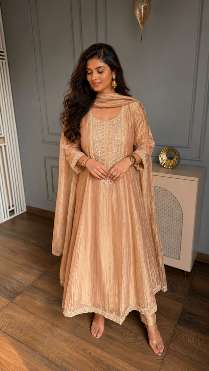Rose gold tissue Anarkali suit with embroidered neckline, matching pants and dupatta.