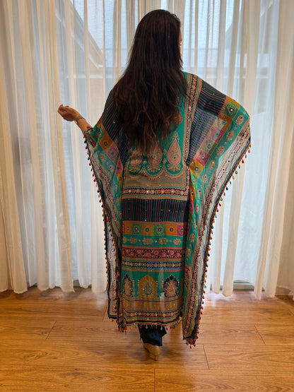 Woman wearing a turquoise printed kaftan kurta with colourful ethnic paisley patterns, tassel trim and matching navy pants, showcasing premium Indian ethnic fashion by Adishee.